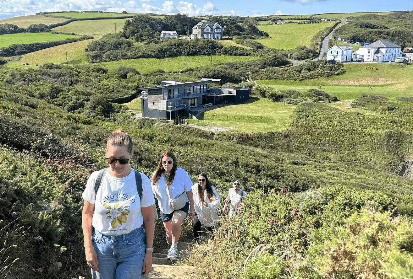 hen group walking the SW coast path with OA Surf Club in the distance