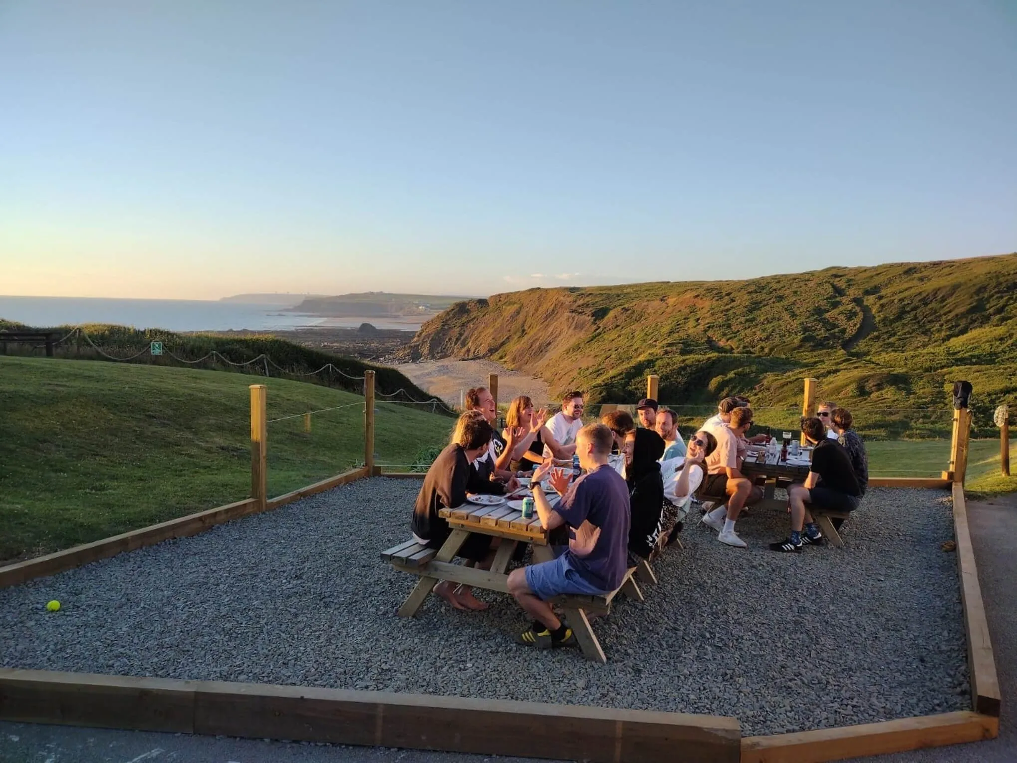 stag and hen dos in cornwall - image of stag do sat at tables in the OA Surf Club grounds, overlooking widemouth bay