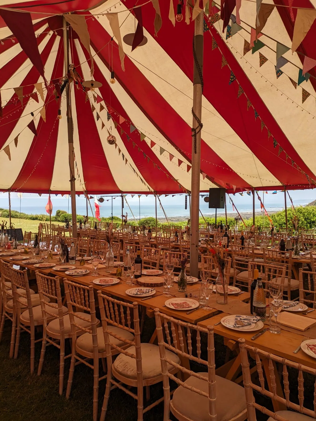 wedding tables laid up with table decorations and seating for 100 people in a marquee
