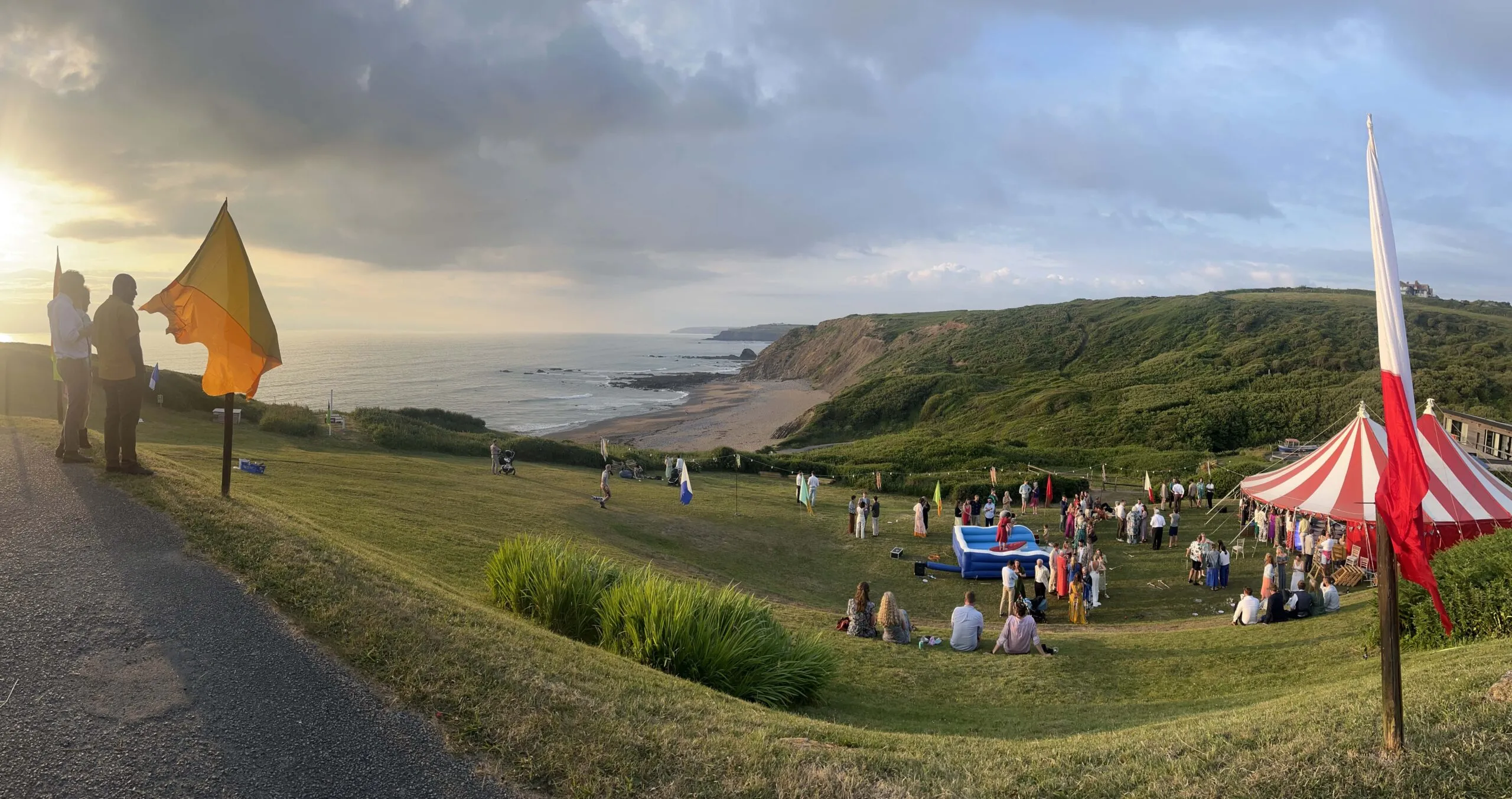 Panoramic picture showing the sea view, beach and large marquee with wedding guests having fun