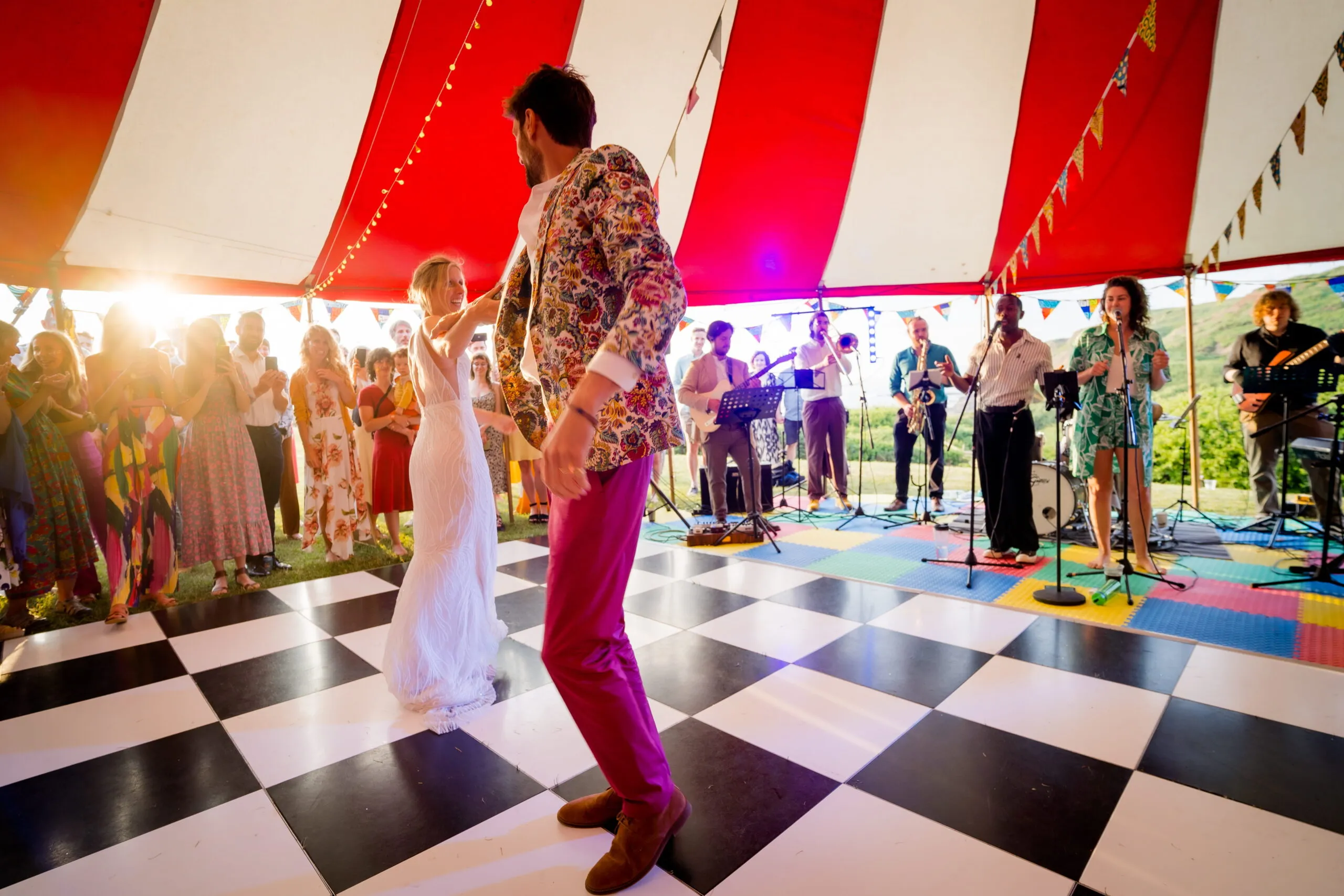 married couple having their first dance in a marquee surrounded by wedding guests