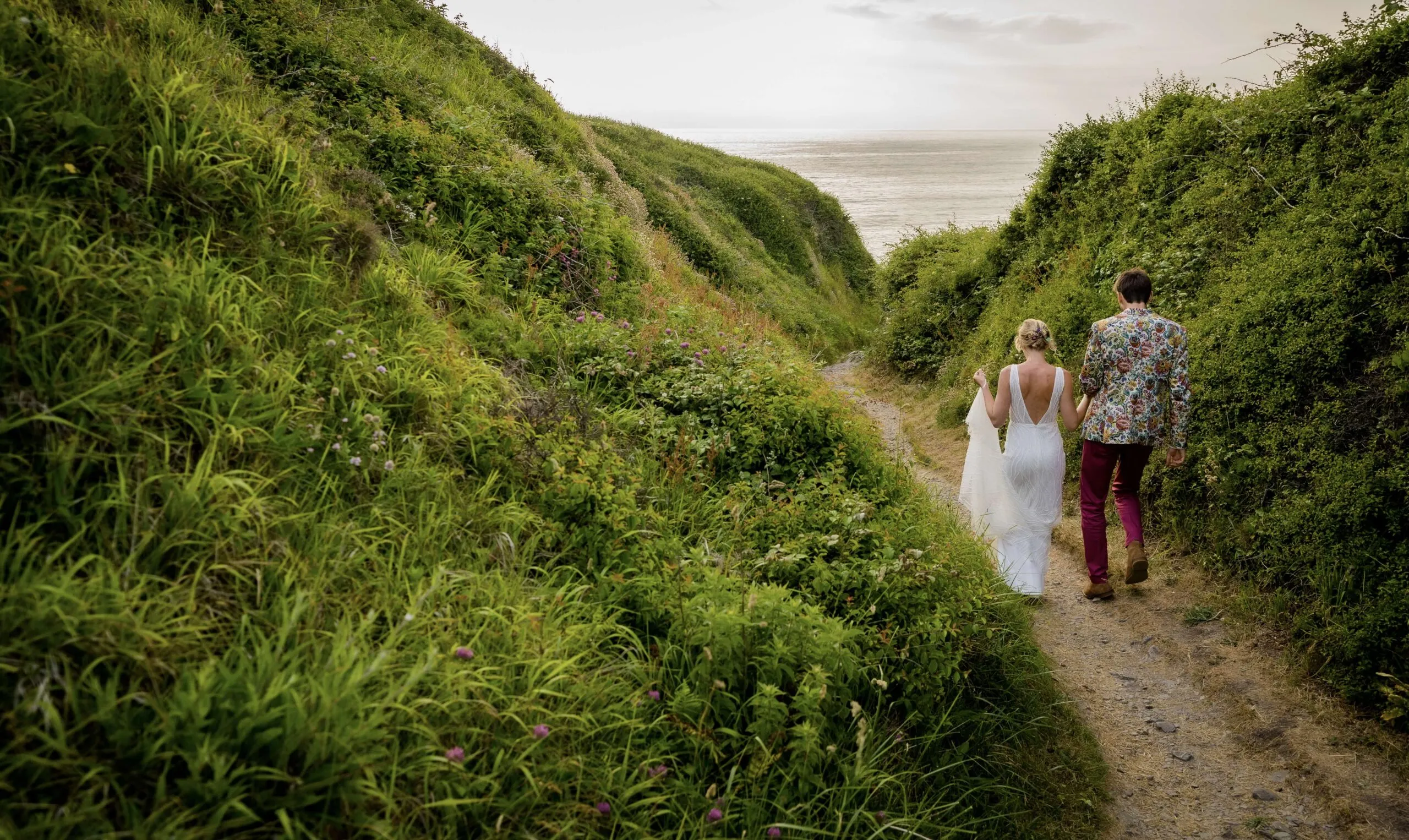bride and groom walking down a path to Watson Mouth secluded beach