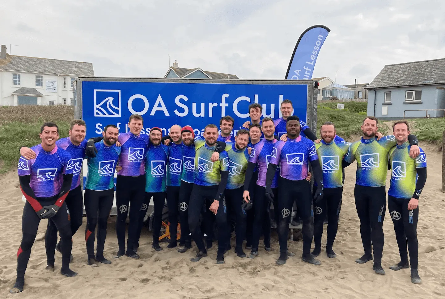 large stag group dressed in wetsuits about to go surfing with OA Surf Club at Widemouth Bay